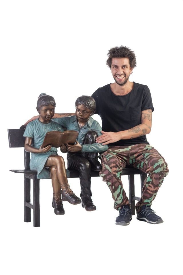 BOY AND GIRL READING A BOOK ON A BENCH